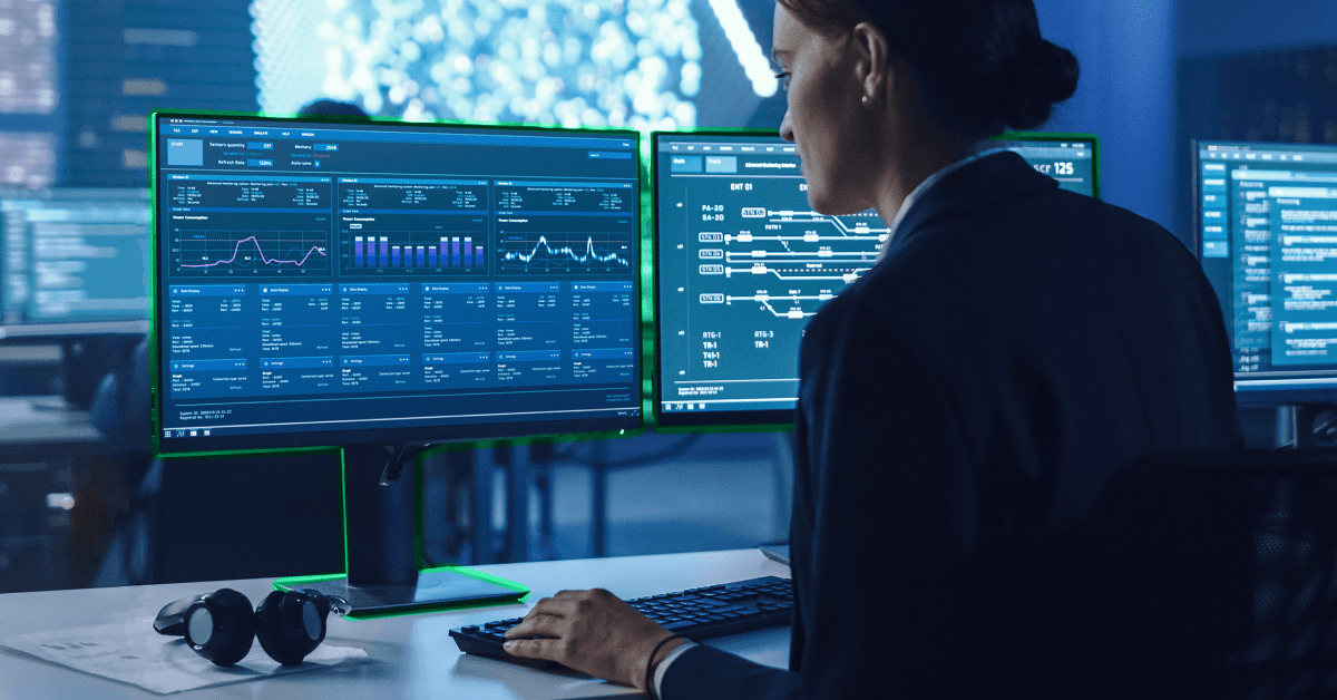 person looking at two screens with data points