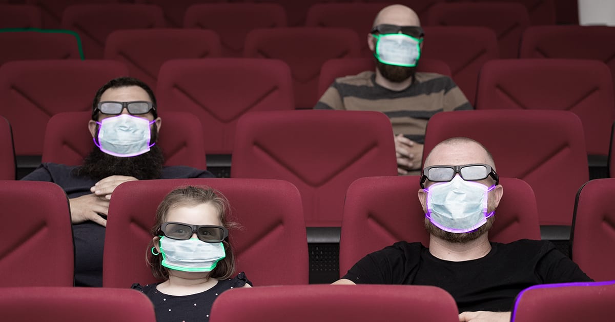 people in movie theater with masks on